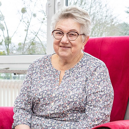 Glückliche Seniorin sitzt im Sessel